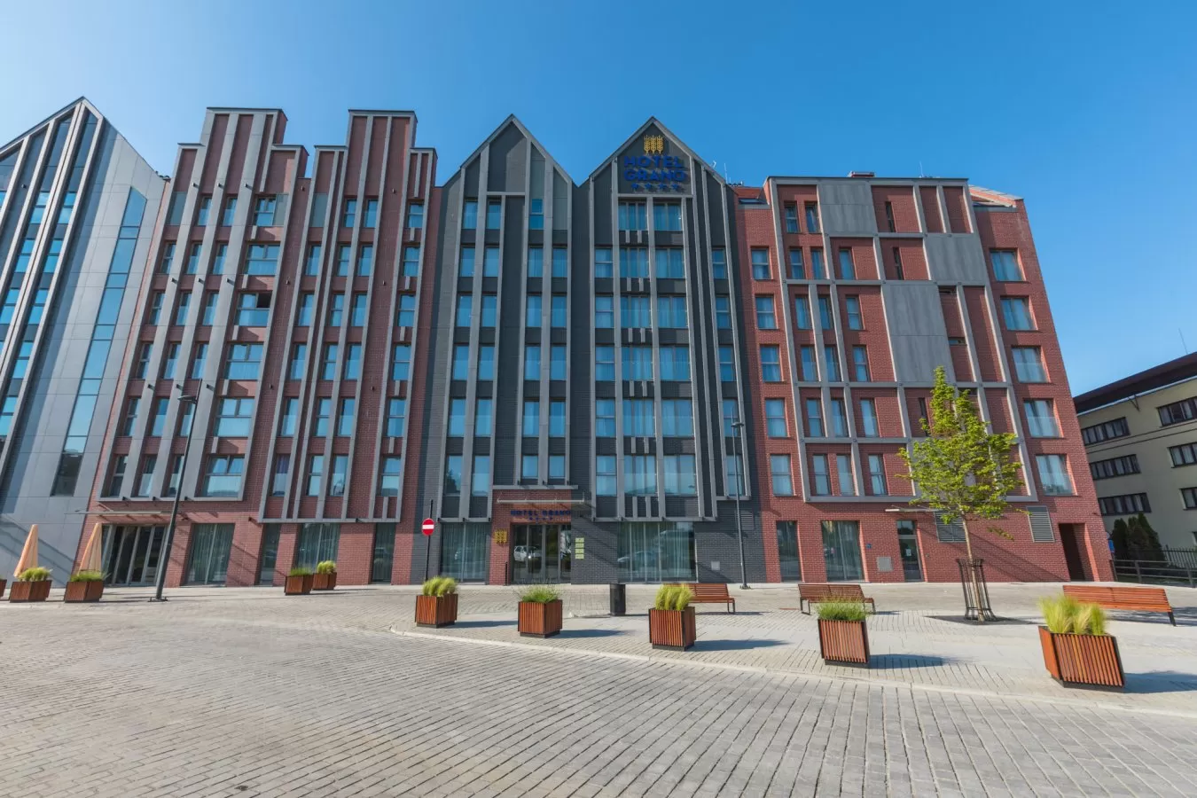 Czy Hotel Grano posiada własny parking oraz czy w jego okolicy znajdują się też inne parkingi?